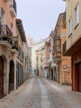 Discover the serene beauty of a charming, colorful street in Spain's picturesque urban setting.
