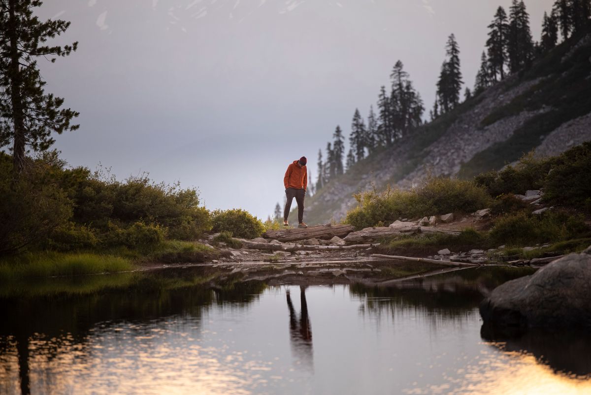 Hiker on a rocky shoreline at dusk, photo by Stephen Leonardi on Pexels