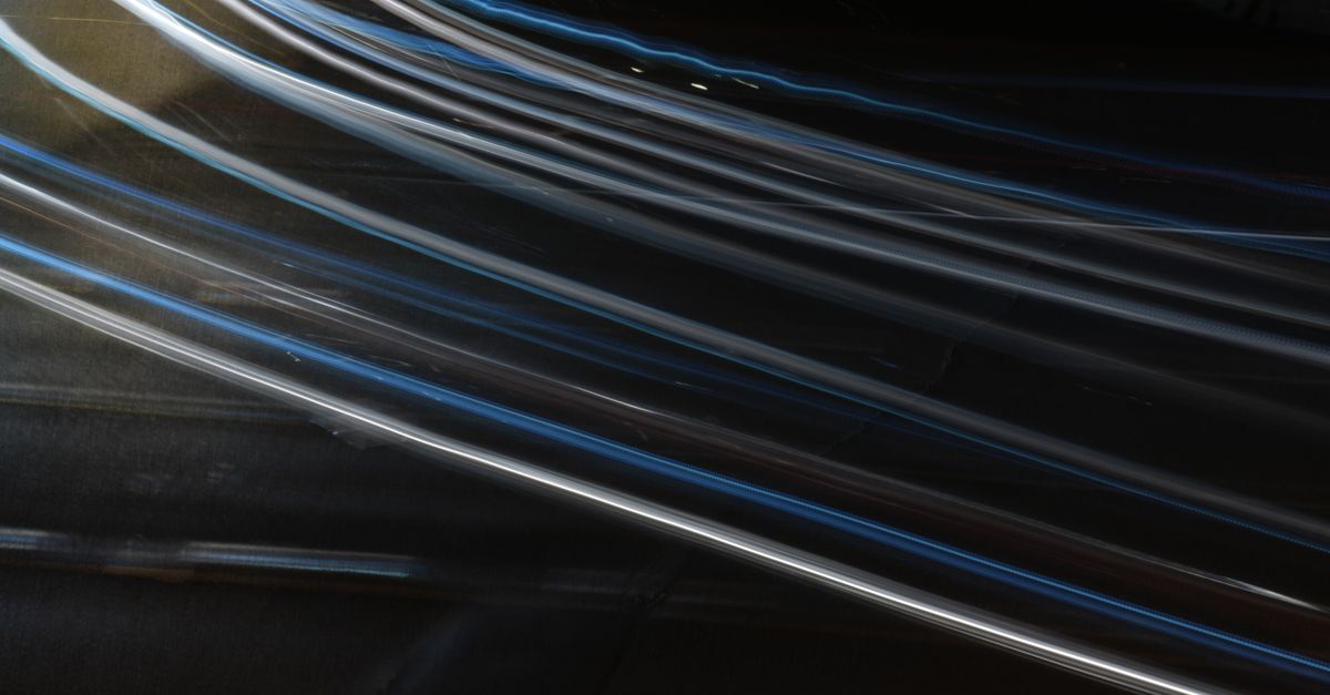 Abstract long exposure light trails captured at night, showcasing movement and dynamism.