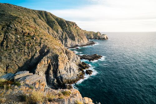 Free Explore the stunning rocky cliffs along the Todos Santos coastline under a vivid sunset. Stock Photo