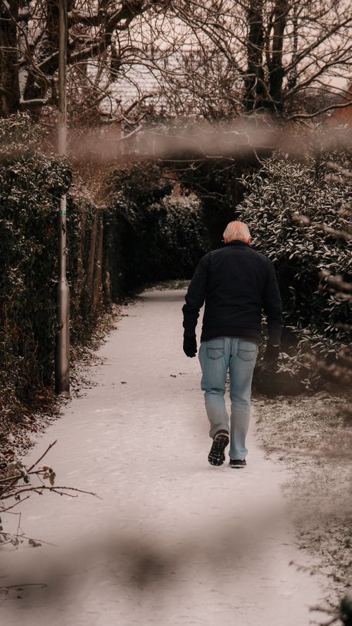 Free A senior man walks on a snow-covered pathway in Thatcham, England during winter. Stock Photo