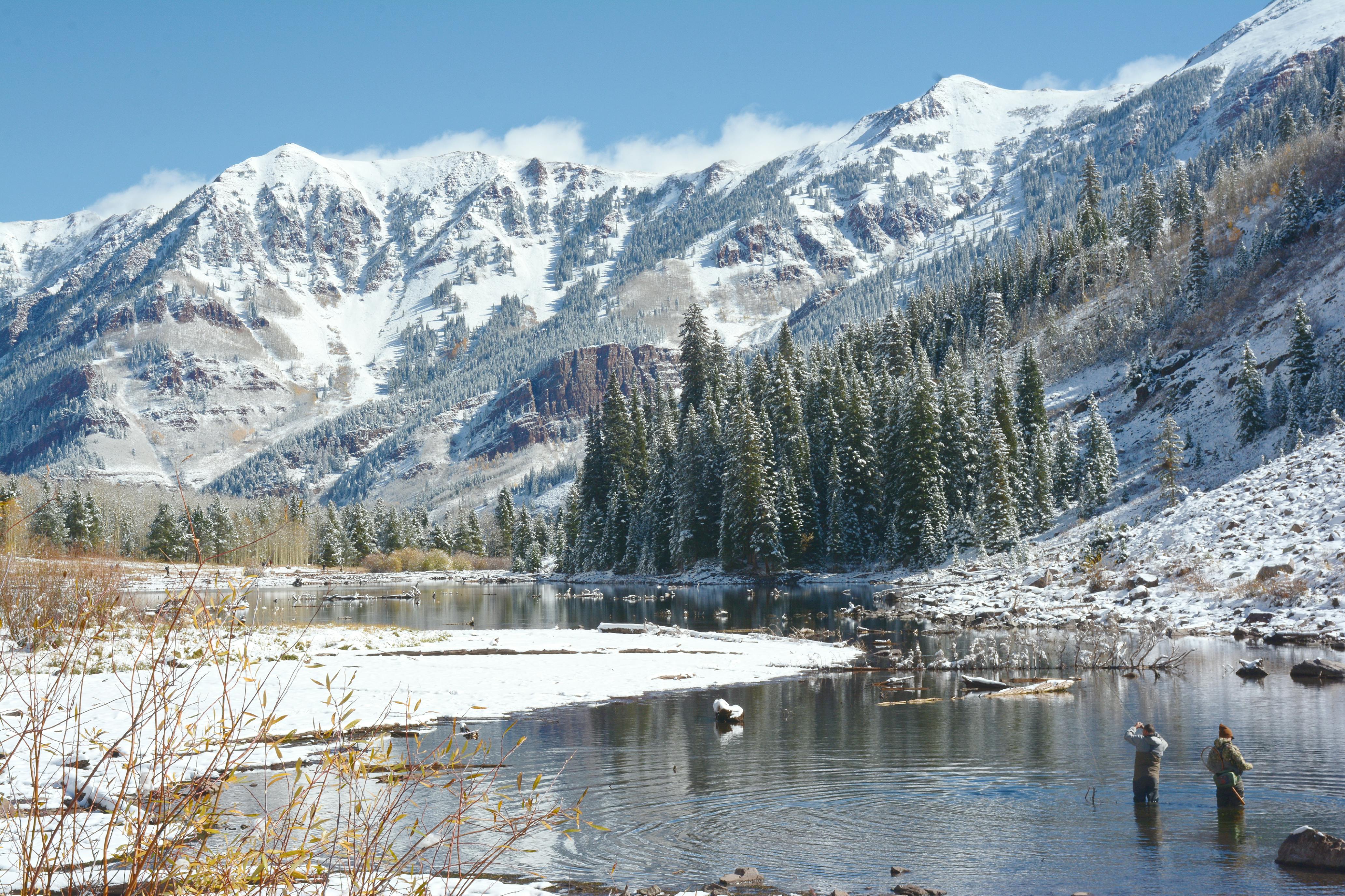 Breathtaking view of the snow-covered Maroon Bells and alpine lake in Aspen, Colorado.