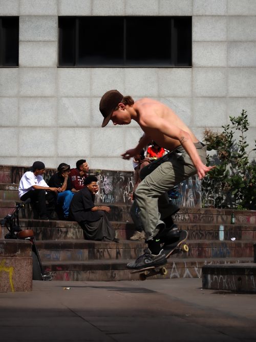 Free Skateboarder performing a trick in a bustling urban environment, capturing youthful energy and city life. Stock Photo