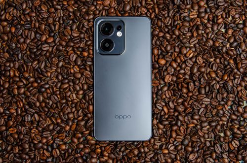 Free A sleek smartphone rests elegantly on a bed of coffee beans, showcasing modern design and technology. Stock Photo