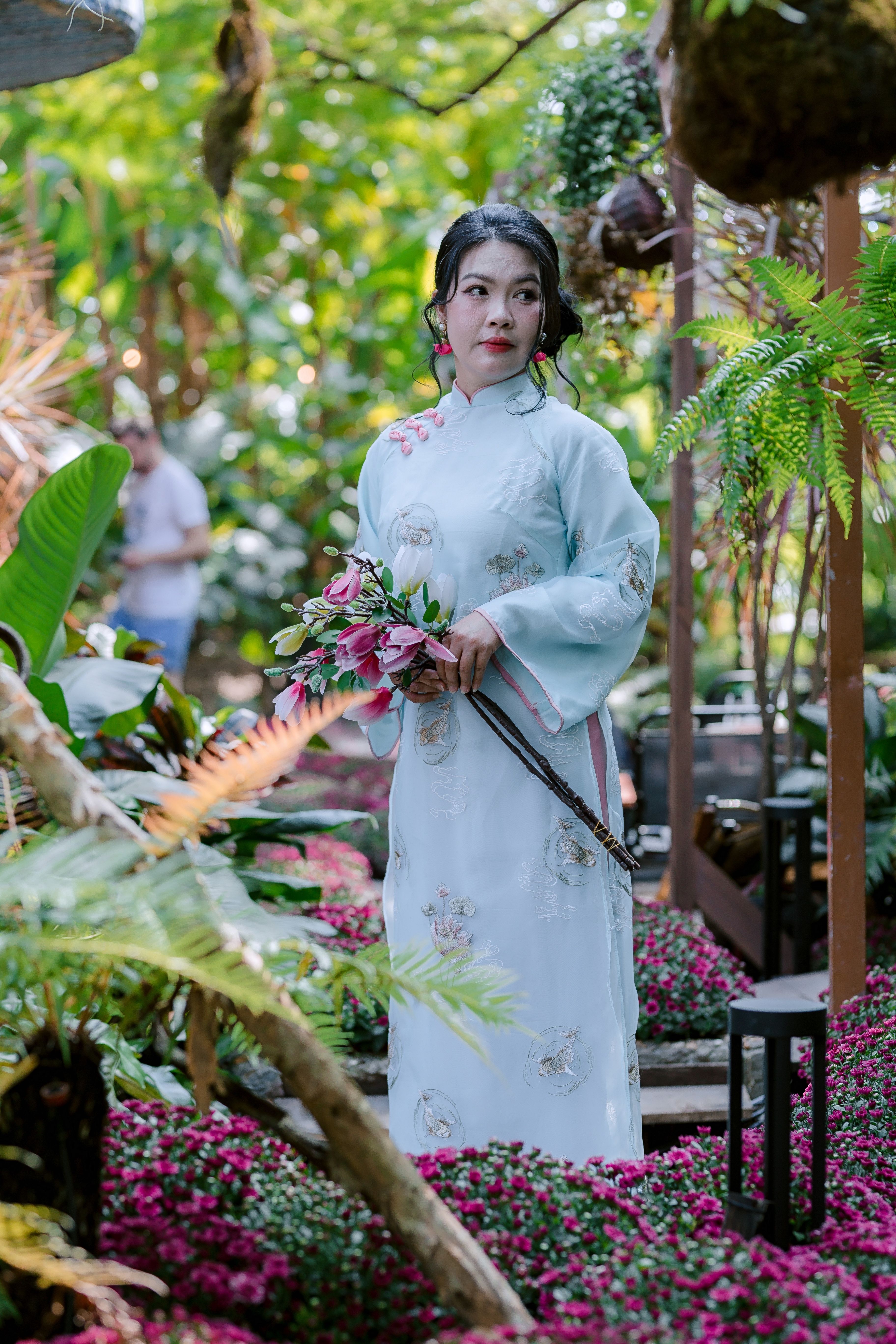 Elegant Woman in Traditional Dress Holding Flowers · Free Stock Photo
