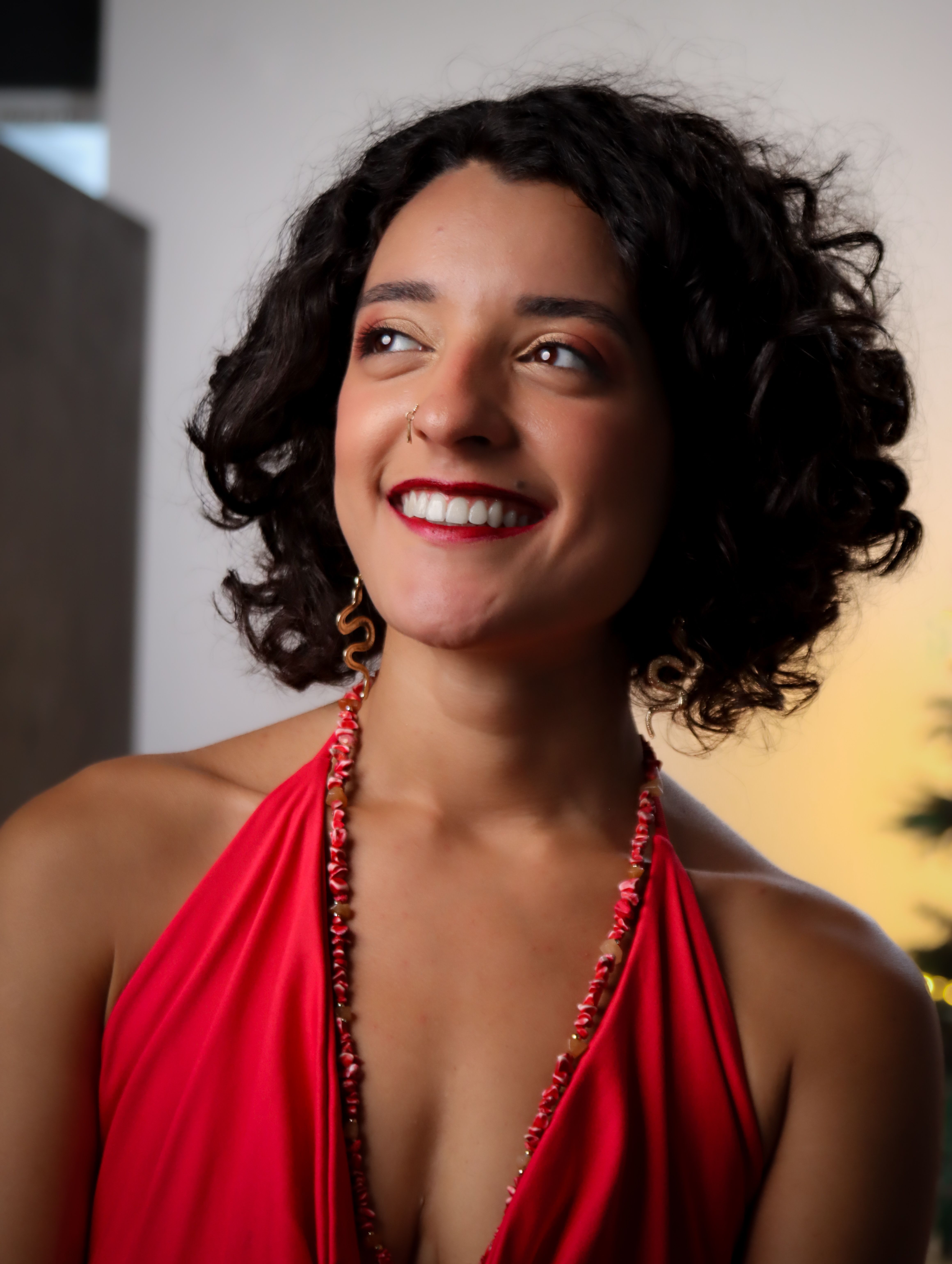 Elegant Woman in Red Dress Smiling Indoors · Free Stock Photo