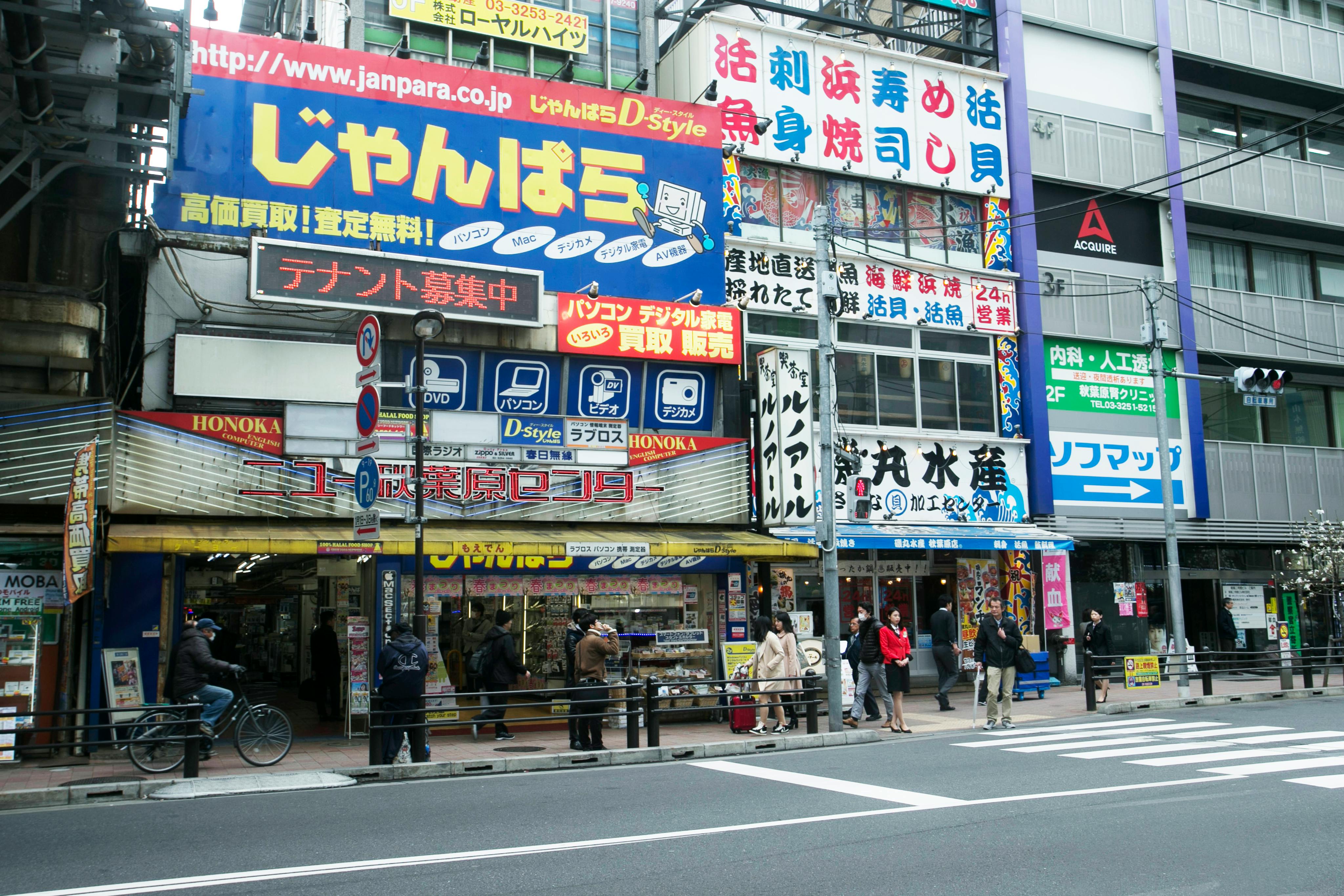 忙しい日に色とりどりの店先と歩行者を見せる、活気のある日本の街路。