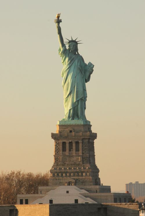 Free Iconic view of the Statue of Liberty in New York City at sunset. Stock Photo