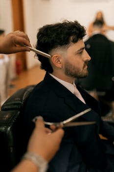 Side view of a man getting a haircut in a barbershop setting.