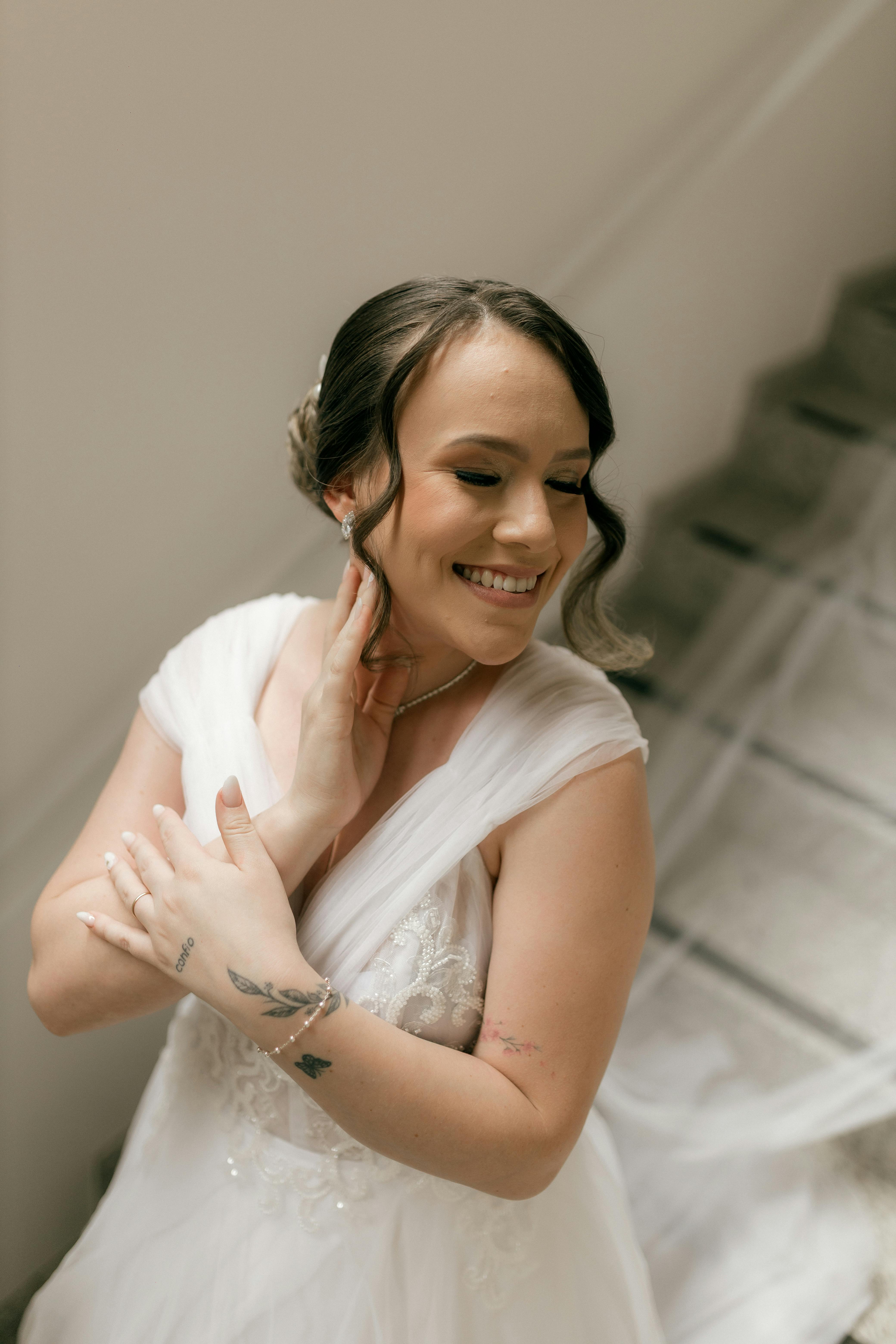 Gratuit Une mariée radieuse, souriant dans une élégante robe blanche, se prépare pour le grand jour. Photos