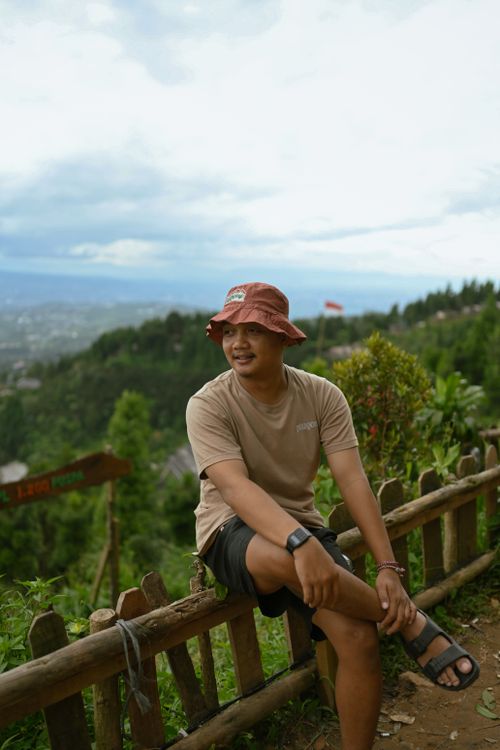 Free Casual young man enjoying the lush green landscape in Indonesia, perfect for outdoor enthusiasts. Stock Photo