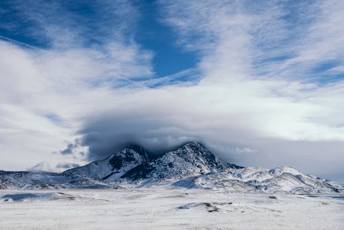 Foto De Montañas Cubiertas De Nieve Bajo El Cielo Nublado