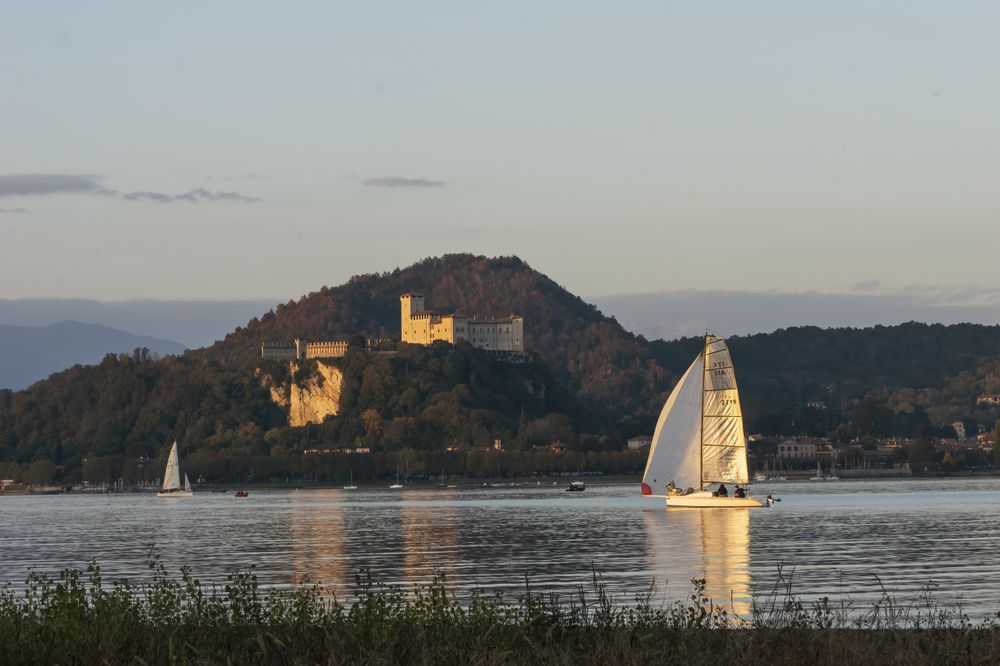 Velier pe Lacul Maggiore lângă castelul Rocca Borromeo, în lumina dimineții