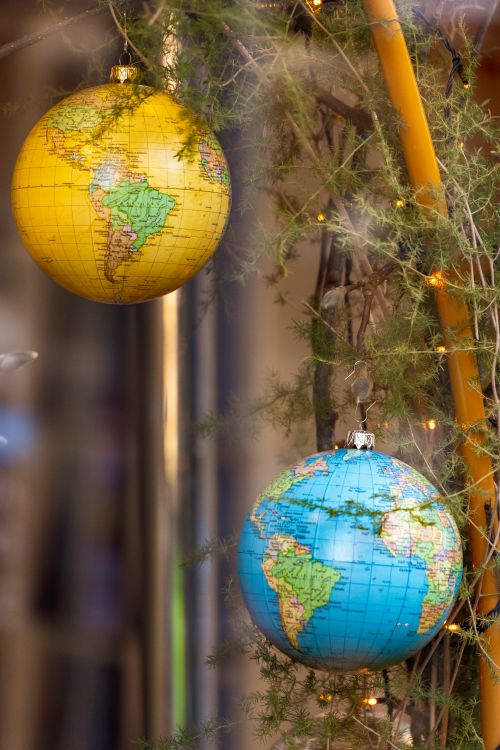 Free Two vibrant globe decorations hanging amidst festive lights, reflecting holiday joy. Stock Photo