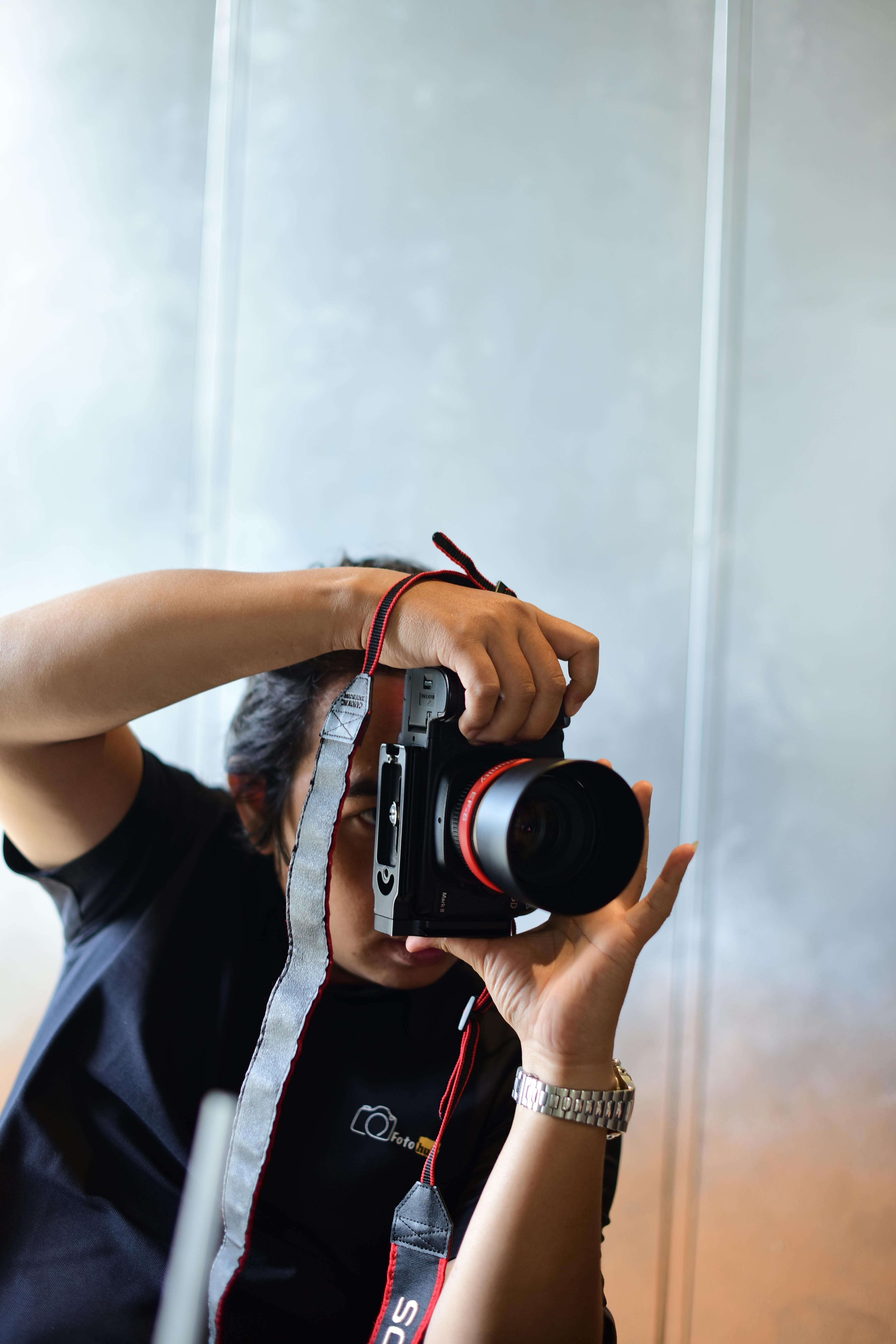 De franc Un fotògraf capturant una escena en interiors amb equip de càmera professional. Foto d'estoc