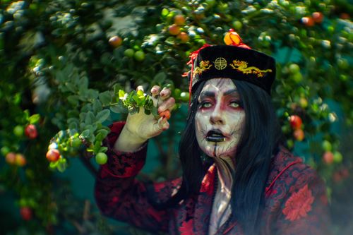 Free A dramatic artistic portrait in nature, featuring unique makeup and colorful attire. Stock Photo