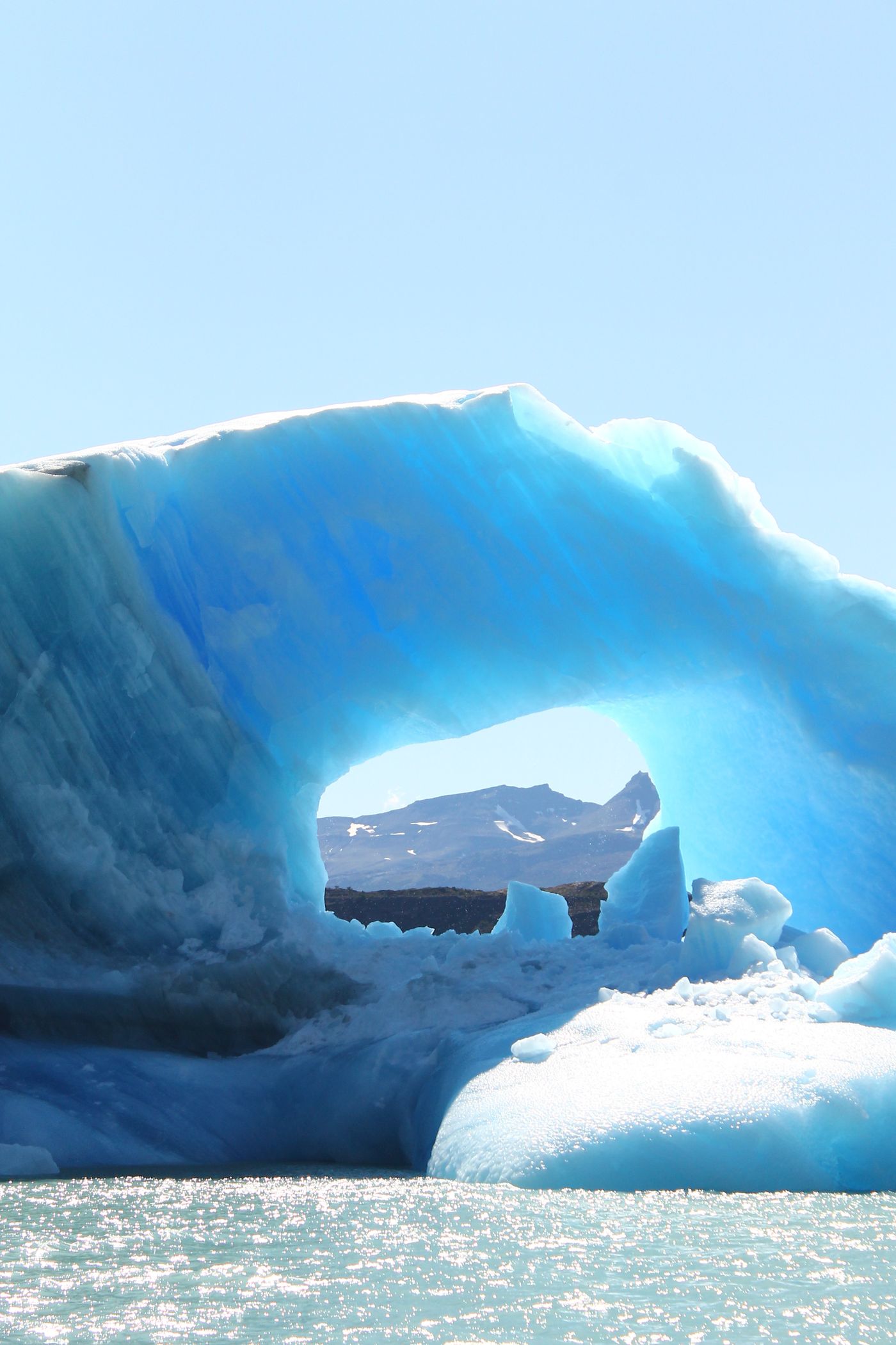 A large blue iceberg floating in a calm polar sea