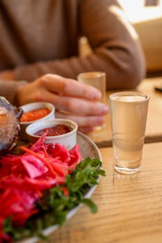 Close-up of a cozy indoor dining scene with colorful food and drinks on a rustic table.