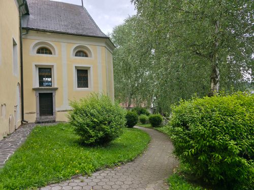 Free A quaint church facade with lush greenery and a winding pathway, perfect for serene walks. Stock Photo