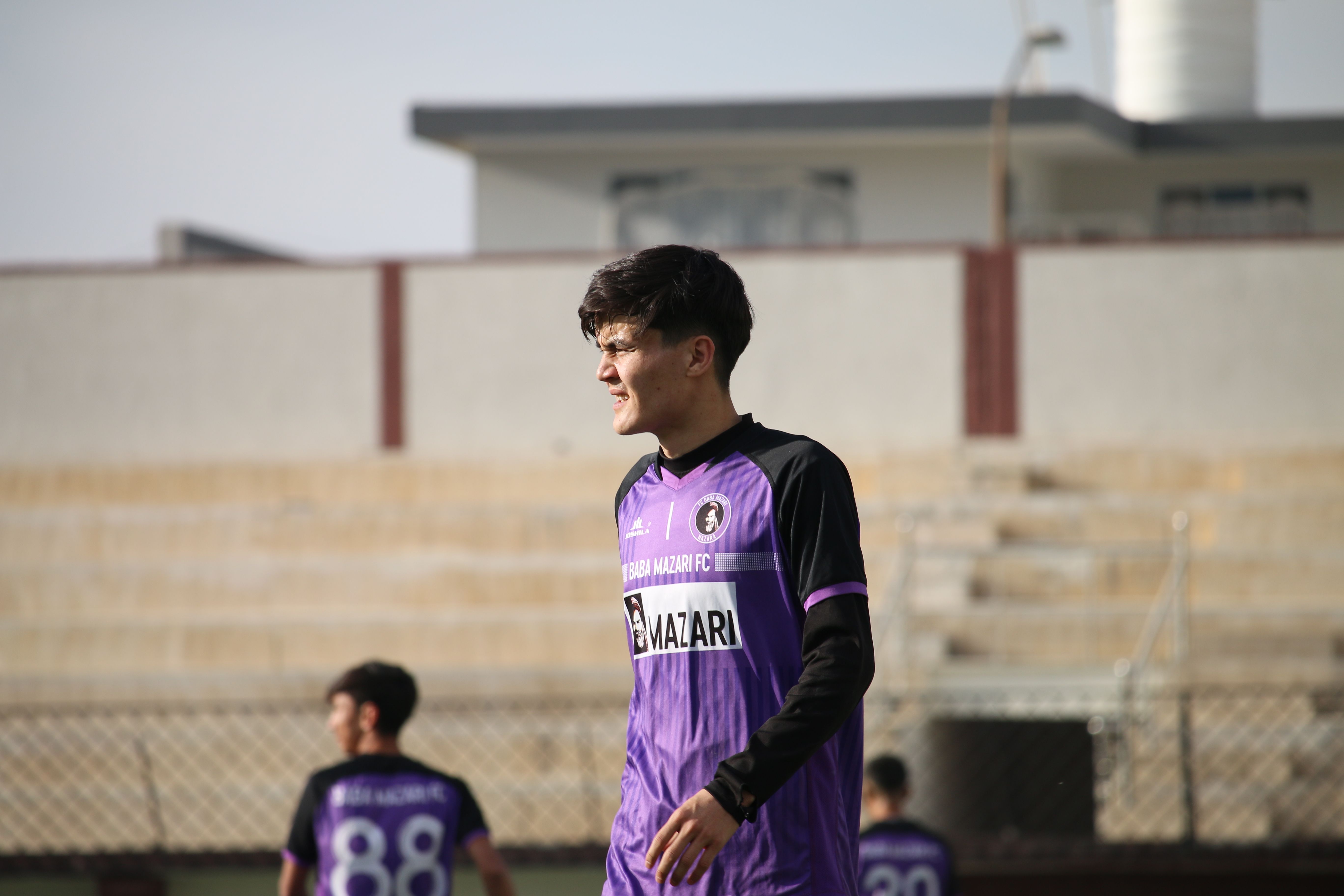 Young Soccer Player on Field in Purple Jersey
