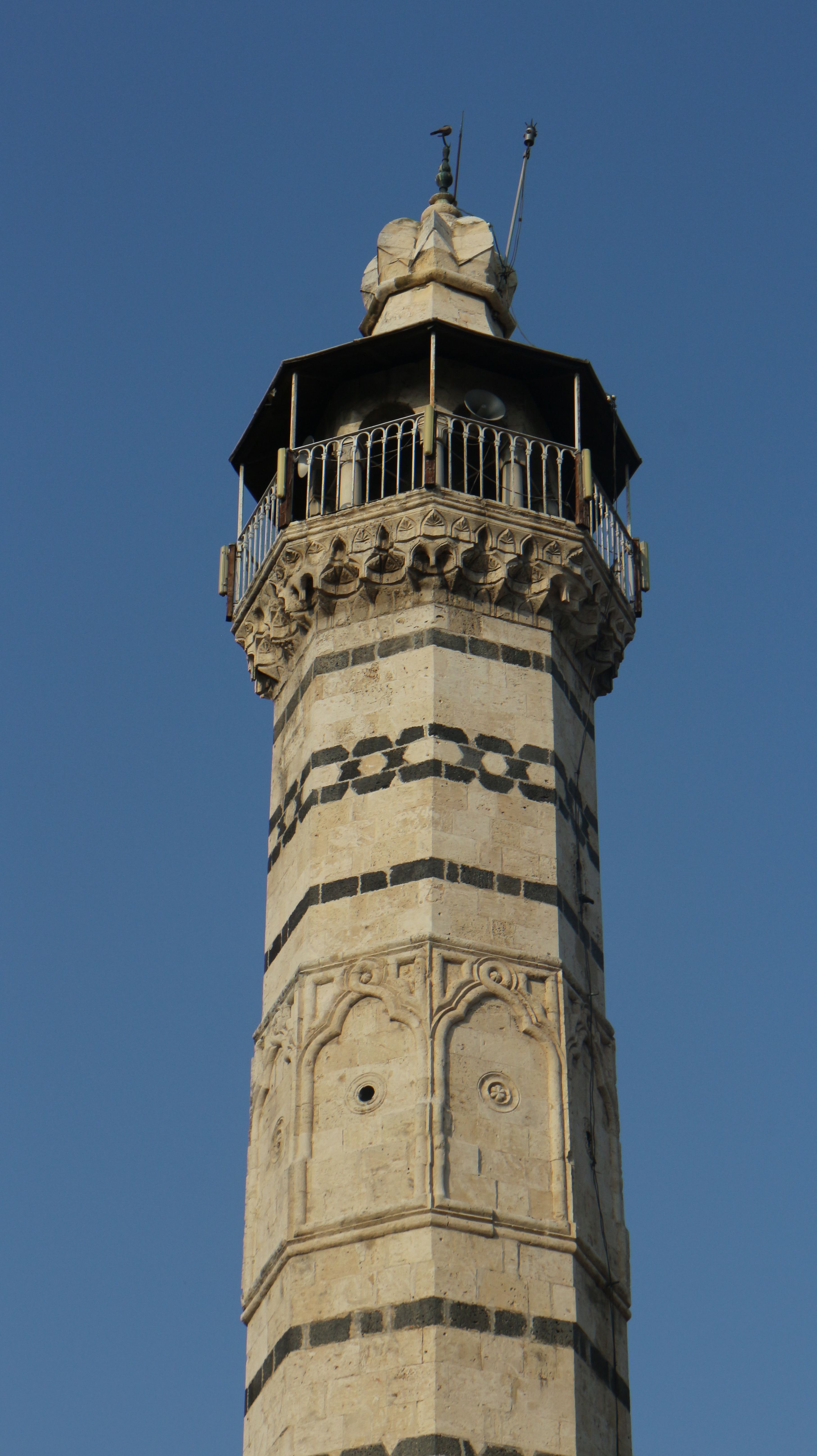 Close-up of an ornate minaret on a clear sunny day showcasing intricate architectural details.