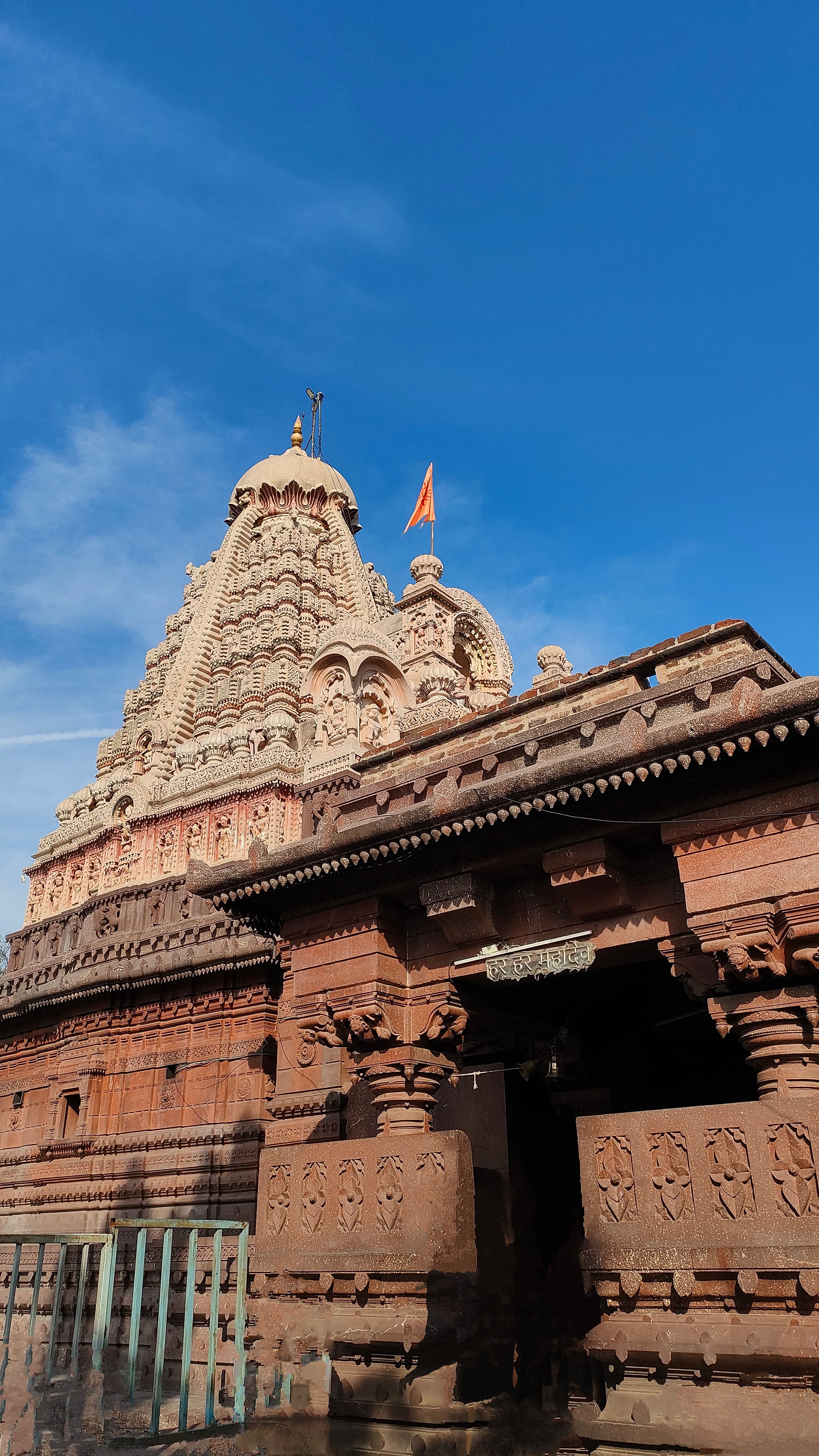 Ancient Indian temple architecture stands majestic under a clear blue sky, showcasing intricate carvings and cultural heritage.