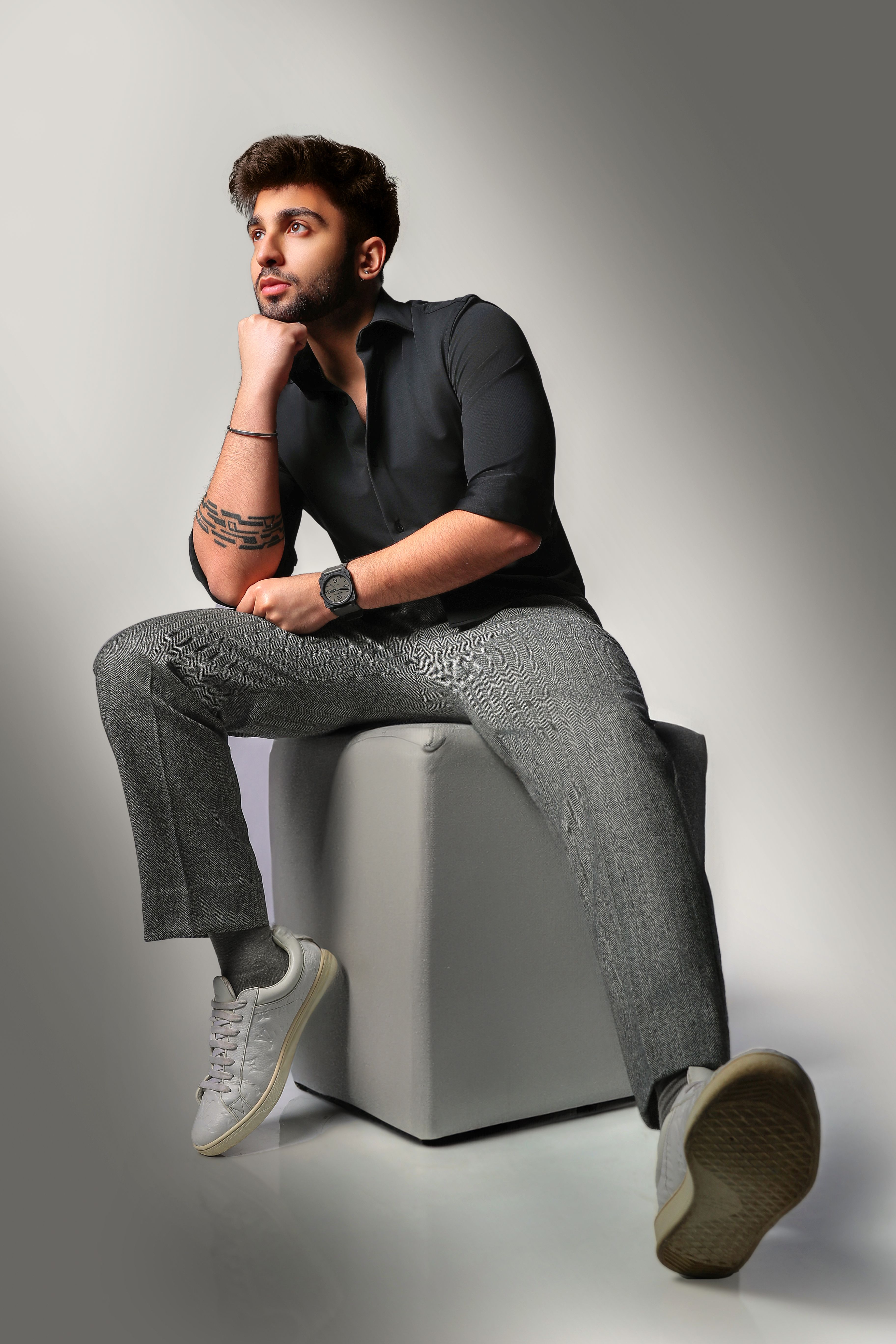Portrait of a fashionable man sitting with modern style indoors.