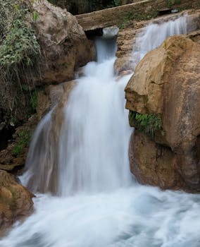 A picturesque waterfall cascading over rocks in a natural setting, showcasing the beauty of nature.