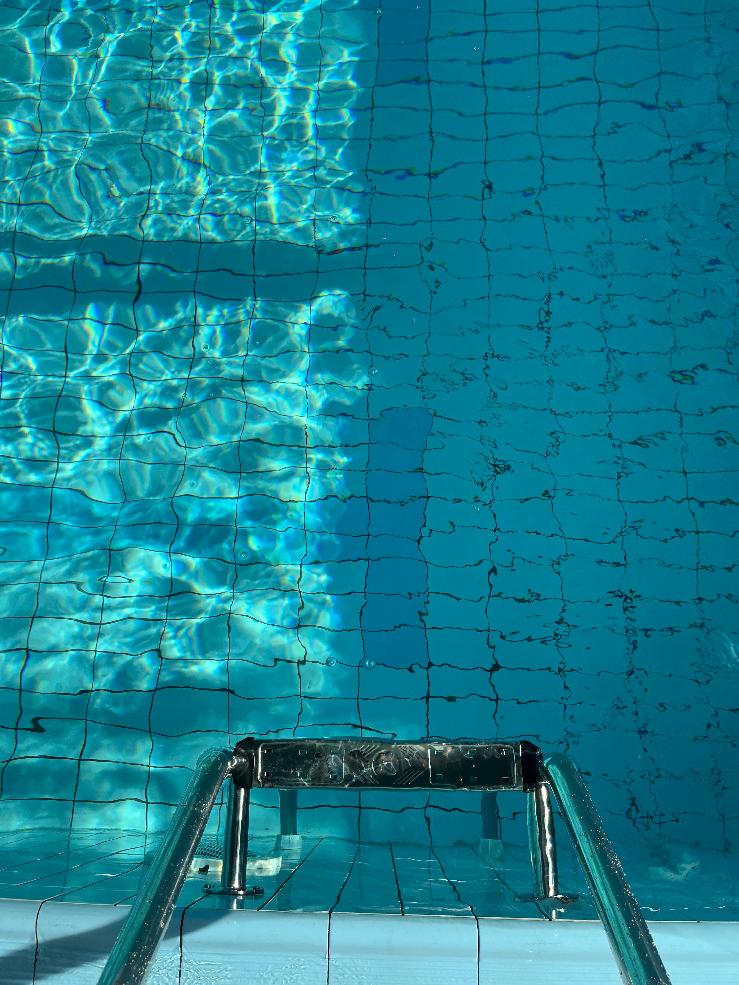 Dive into the cool, refreshing waters of a swimming pool captured from above.