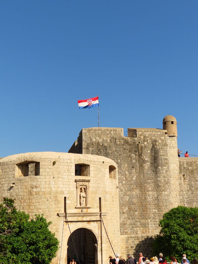 Stone walls and gate of Dubrovnik old town with the Croatian flag