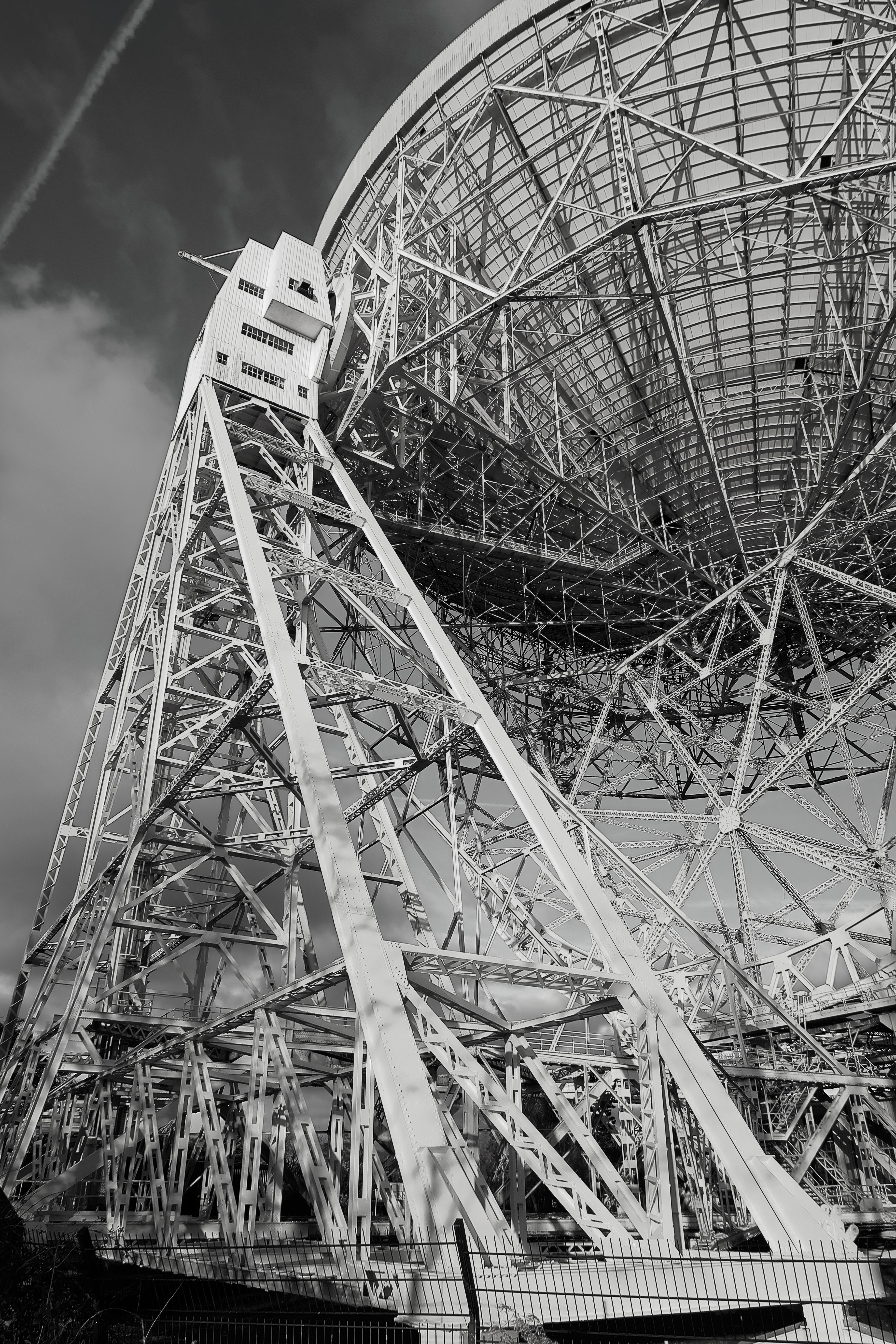 Dramatic black and white photo of Jodrell Bank Observatory's radio telescope in England.