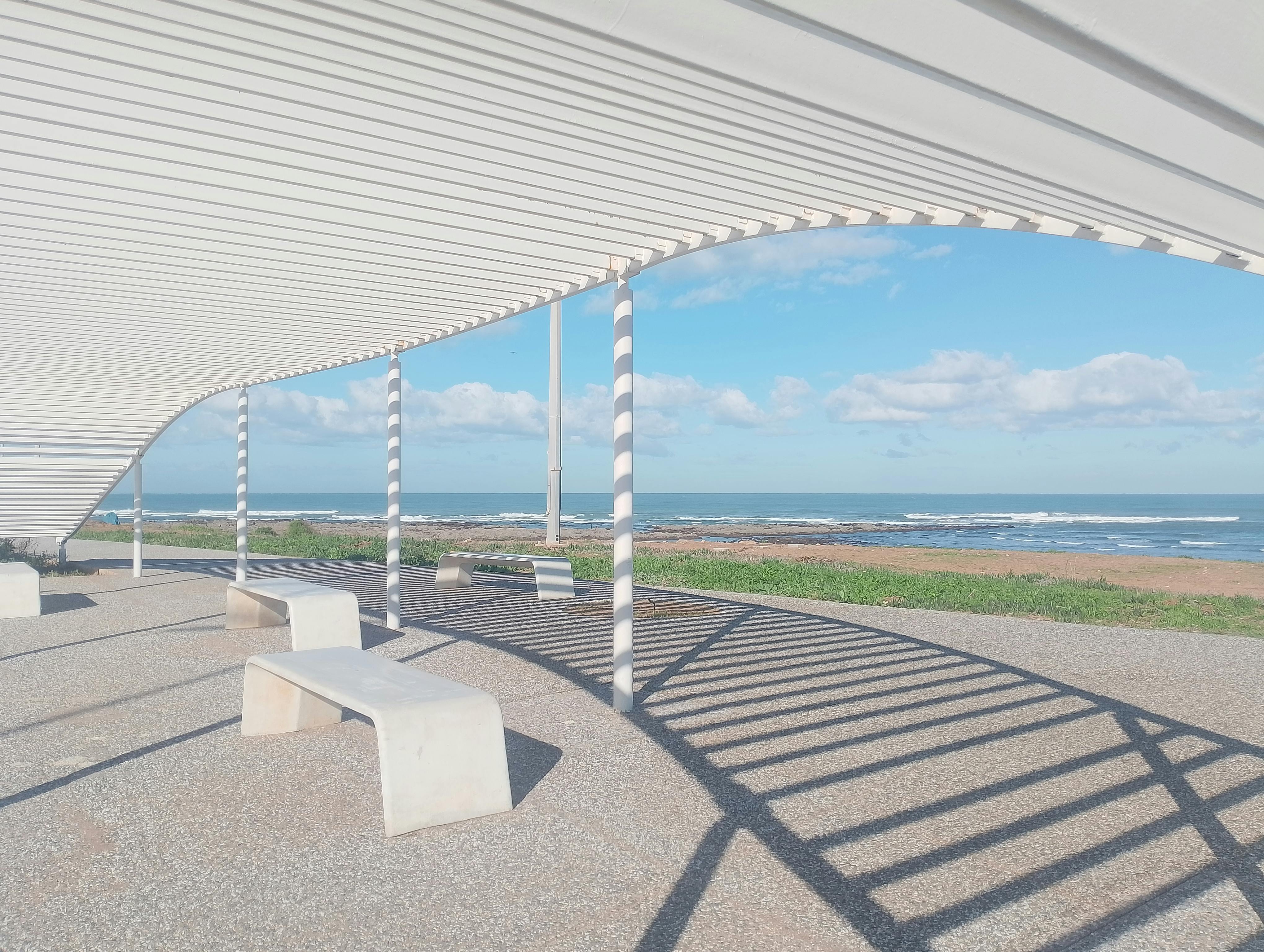 Contemporary pergola with benches overlooking the Casablanca coastline. Sunny day with ocean views.
