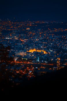 Stunning aerial night view of Tbilisi, Georgia, showcasing illuminated cityscape and vibrant lights.