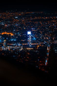 Explore the vibrant night skyline of Tbilisi, Georgia with its iconic illuminated landmarks.