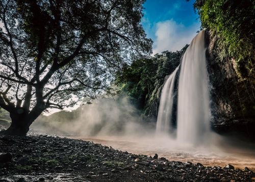Free Captivating view of a waterfall cascading in Jawa Barat, framed by lush greenery. Stock Photo