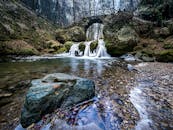 在宁静的森林环境中，美丽的瀑布从乡村石桥下倾泻而下