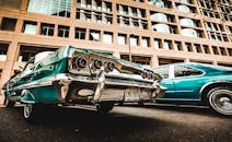 一辆经典的老爷车停在现代建筑背景的城市街道上