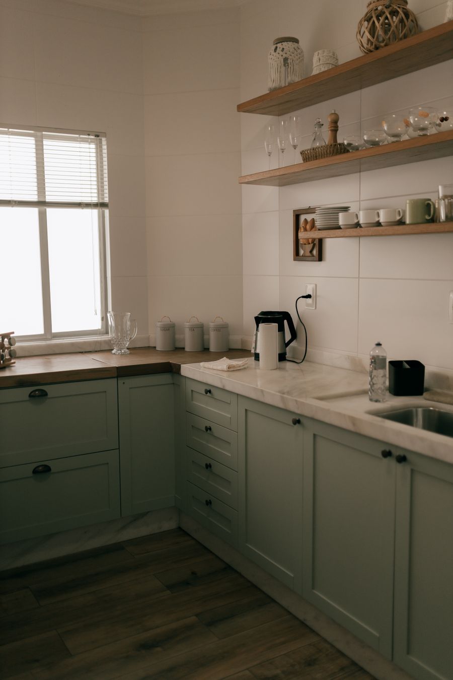 Sage green kitchen with oak open shelving, photo by Alexander Mass on Pexels