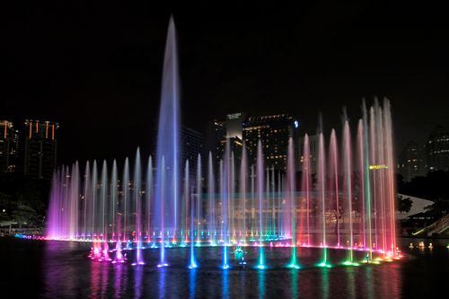 Free Colorful illuminated fountain show in cityscape at night. Stock Photo