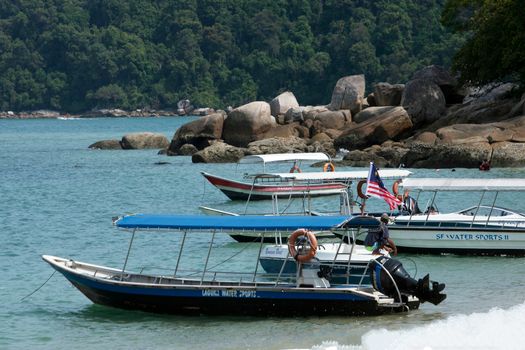 Idyllic view of boats moored at a clear water beach on Pangkor Island, Malaysia.
