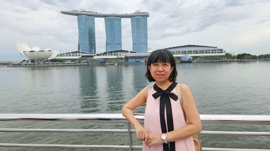 Woman posing by Marina Bay Sands with a cloudy sky in Singapore.
