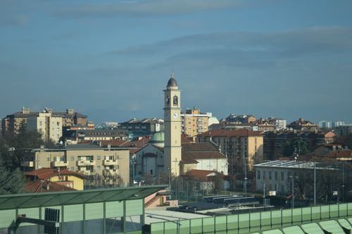 Free Scenic cityscape with a prominent clock tower against a clear blue sky, showcasing urban architecture. Stock Photo