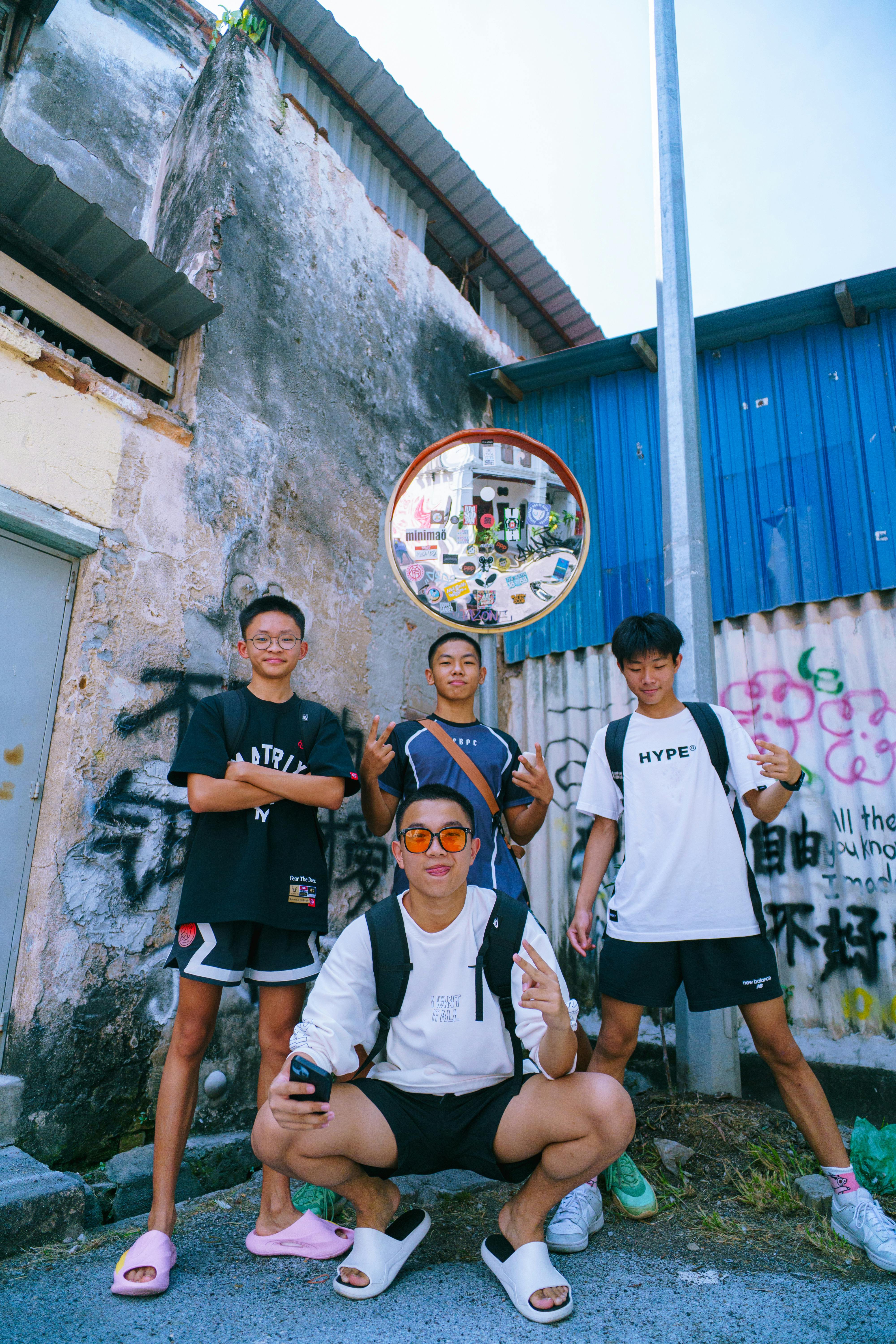 De franc Quatre amics posen jugant amb un teló de fons de grafits urbans a la llum del dia. Foto d'estoc