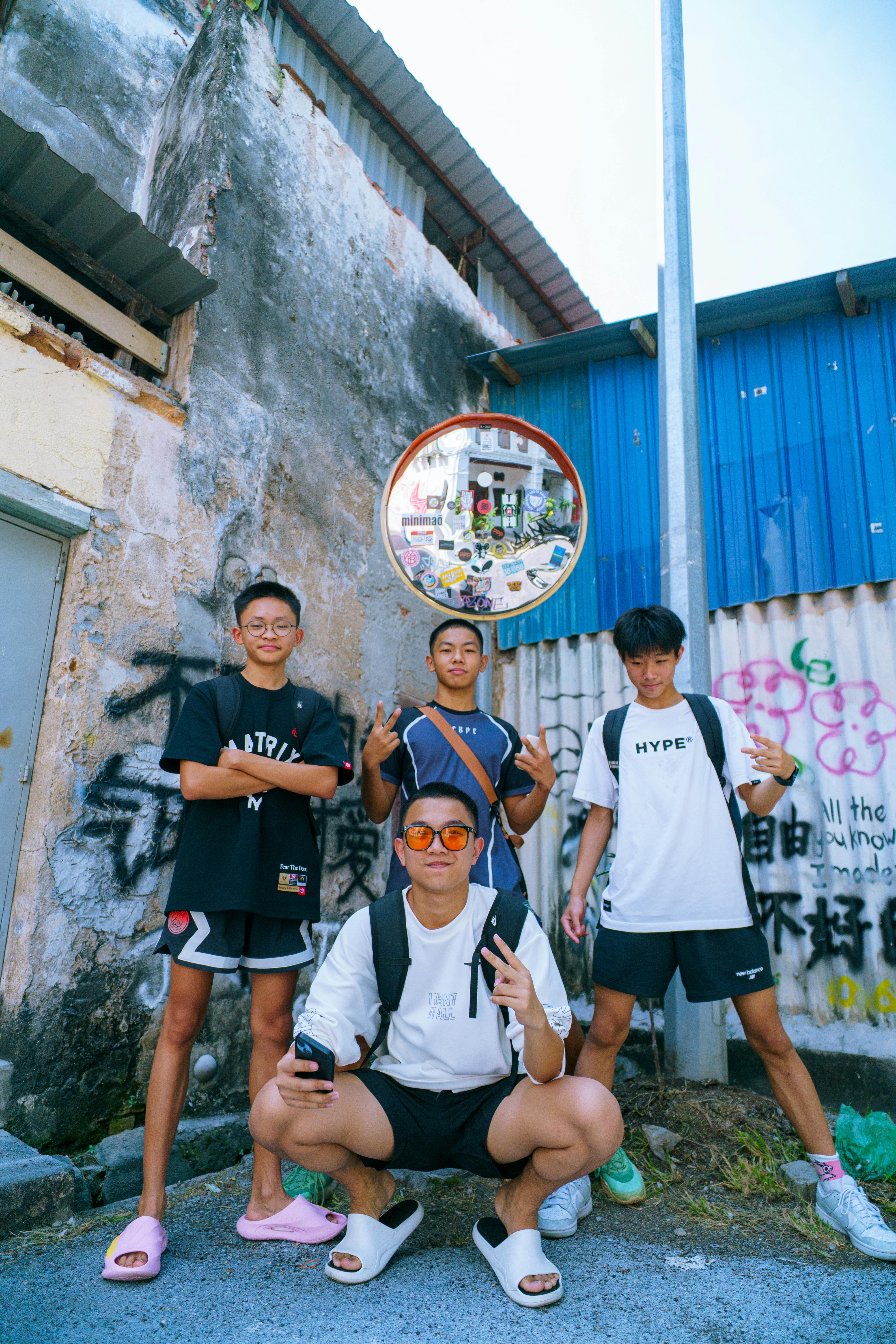 De franc Un grup d'adolescents posant amb confiança amb roba d'estil urbà amb un teló de fons urbà. Foto d'estoc