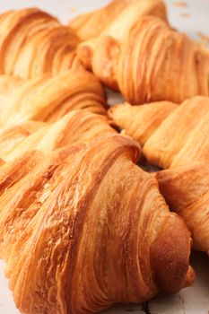Close-up of golden, flaky croissants showcasing layers and texture, ideal for bakery promotions.