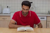 Man Reading Book in Home Kitchen Setting
