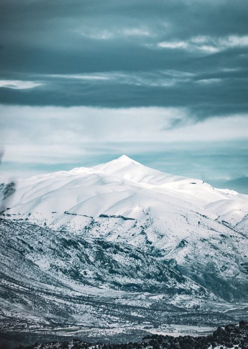 Free Breathtaking view of snow-covered Mount Nemrut under a dramatic sky, perfect for winter travel enthusiasts. Stock Photo
