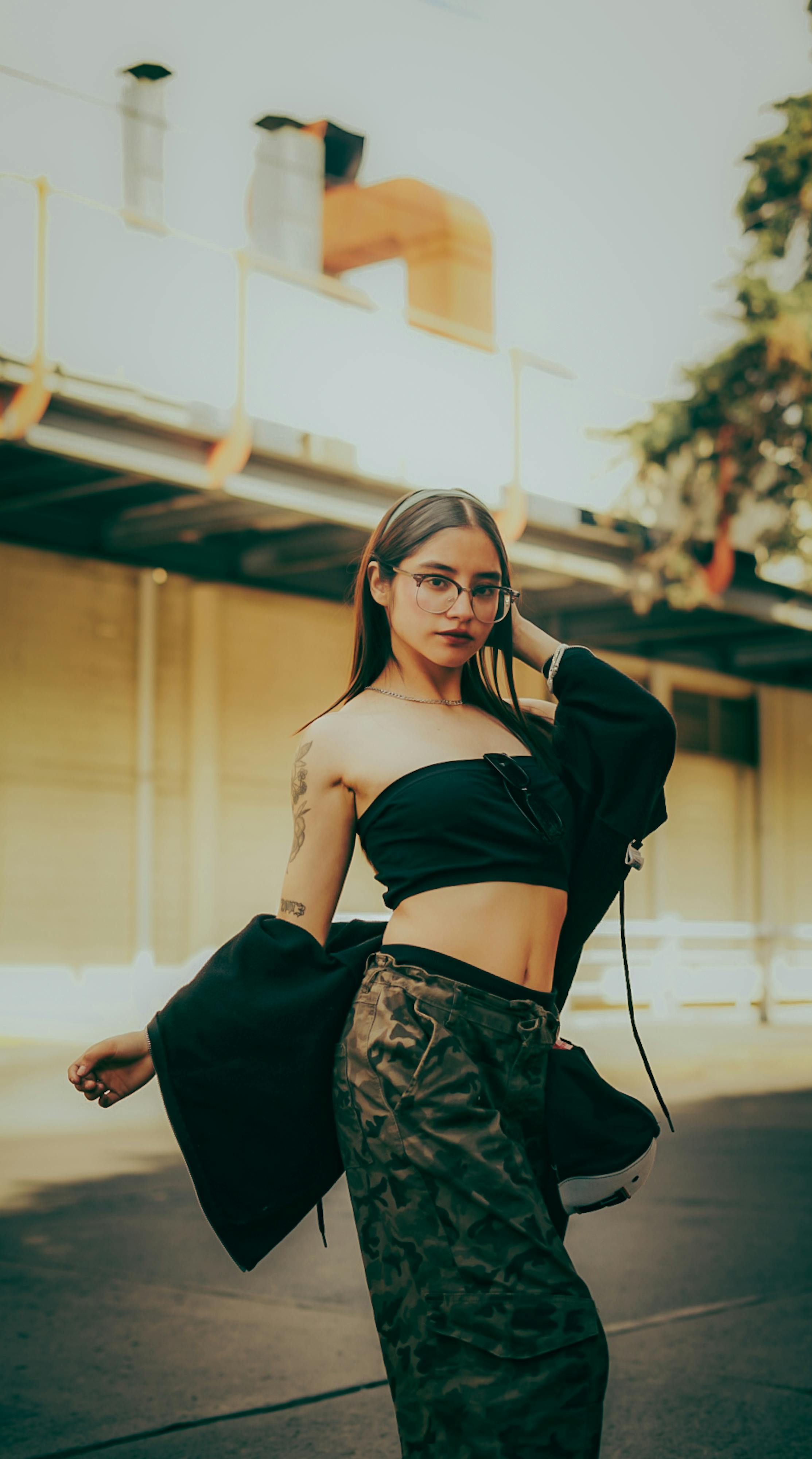 Zadarmo Sebavedomá žena v trendy móde stojí v mestskom prostredí a predvádza moderný štýl. Fotka z fotobanky