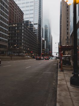 Urban street scene with tall skyscrapers and mid-day traffic.