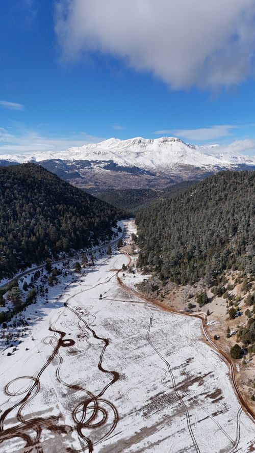 Free Breathtaking aerial view of a snowy mountain landscape in Antalya, Türkiye, with winding paths and a crisp blue sky. Stock Photo